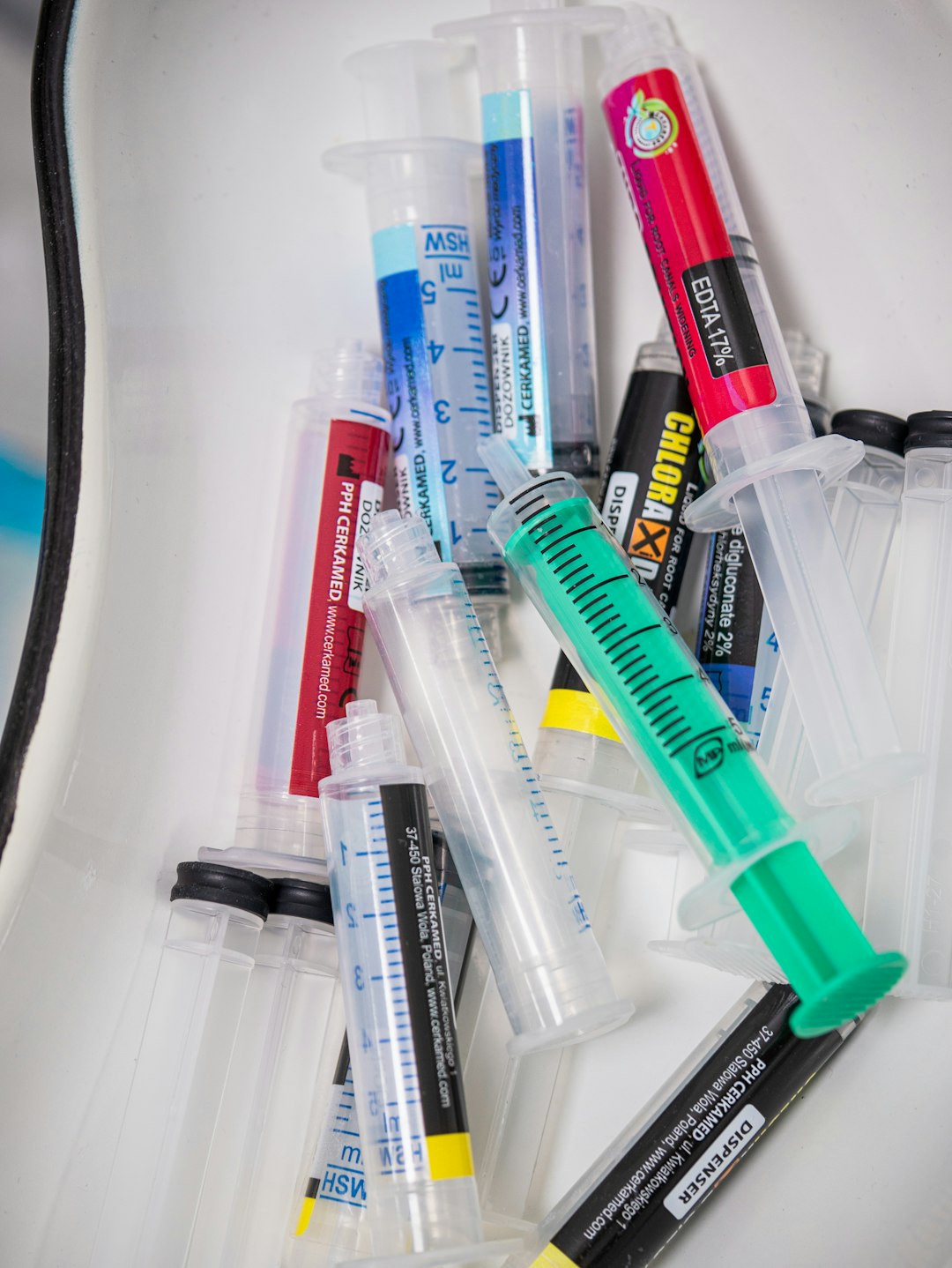 Used medical syringes are discarded in a container.