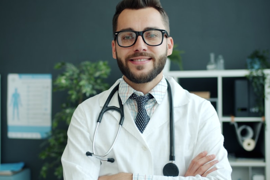 a woman standing in front of a desk with a laptop