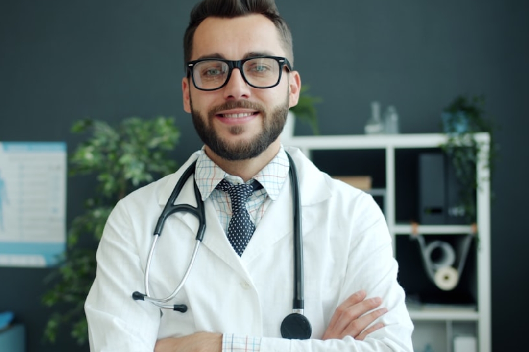 a woman standing in front of a desk with a laptop