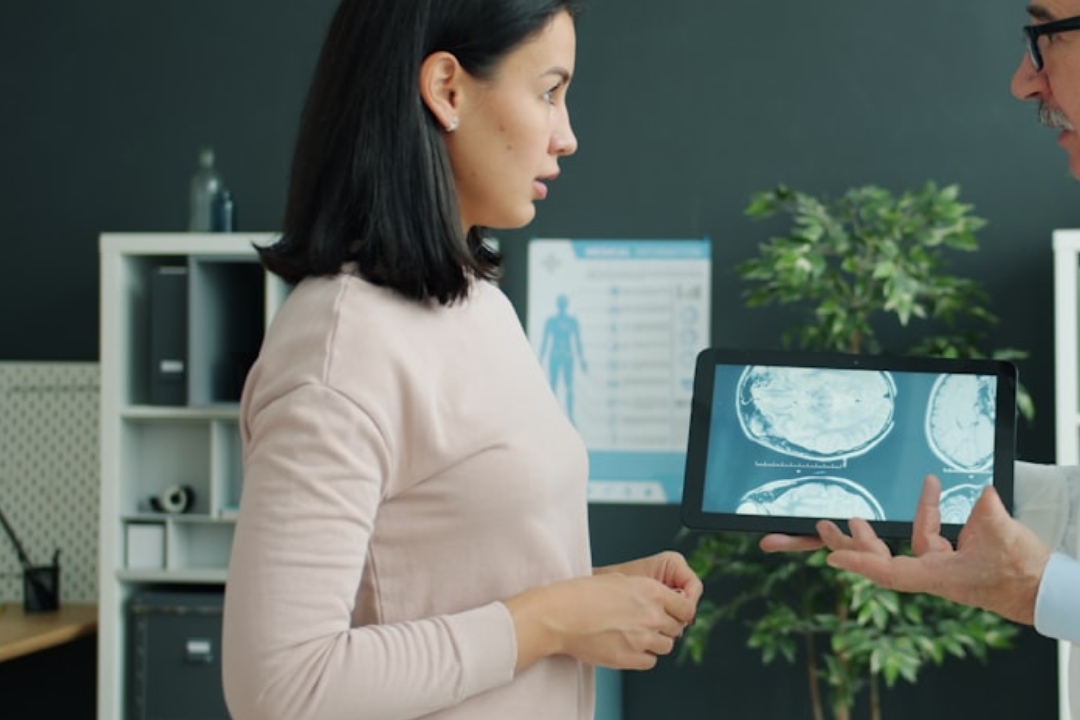 A woman pets her dog on a couch.
