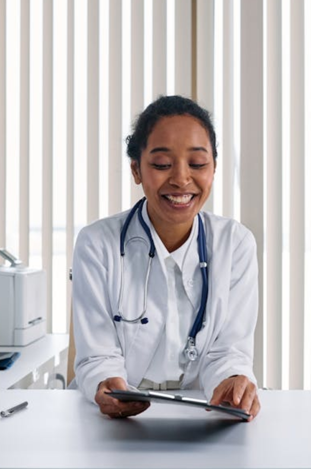 a woman is hiding under a blanket on a bed