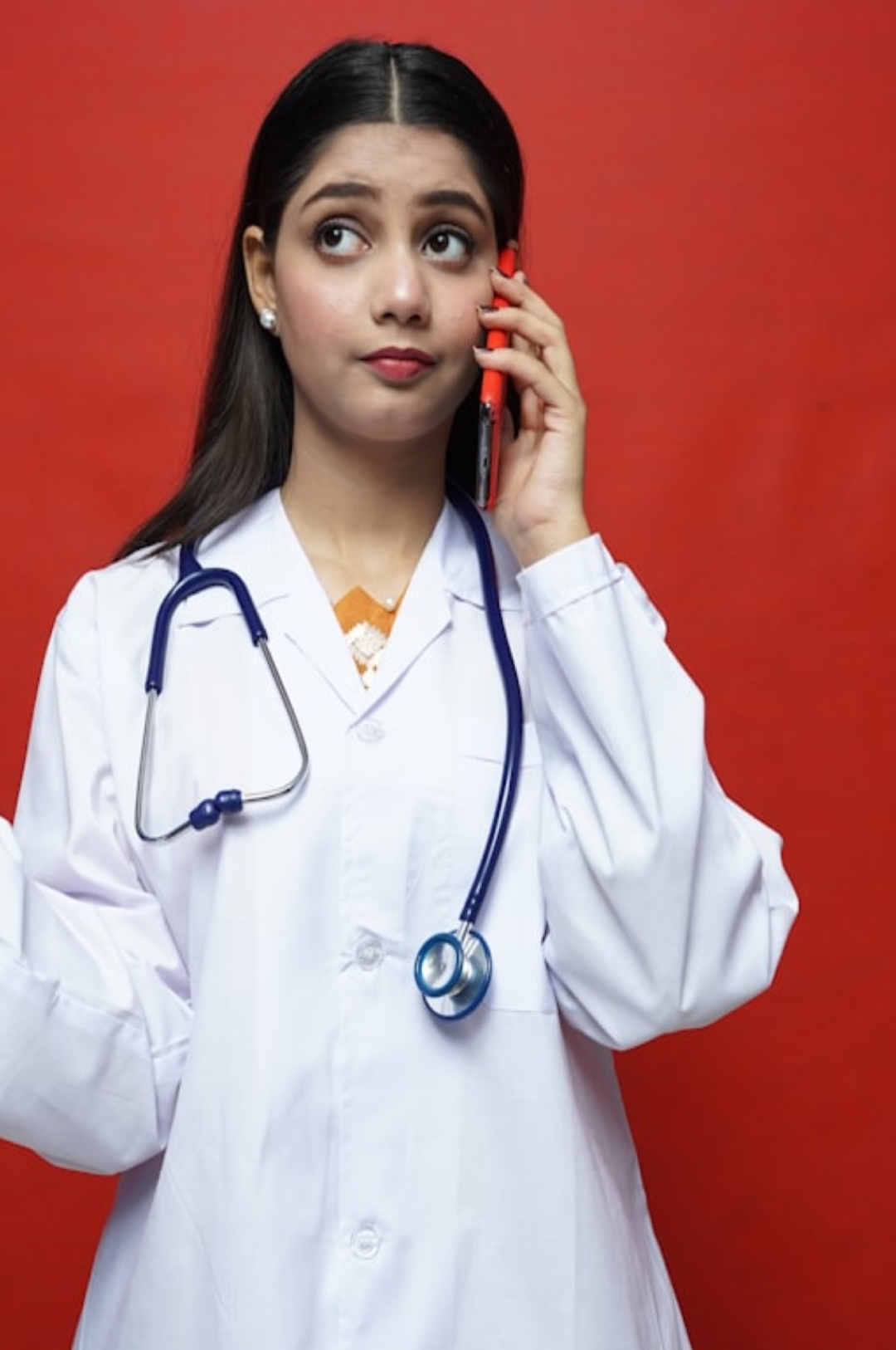a woman is hiding under a blanket on a bed